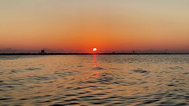 Sunrise reflecting on water with gentle waves