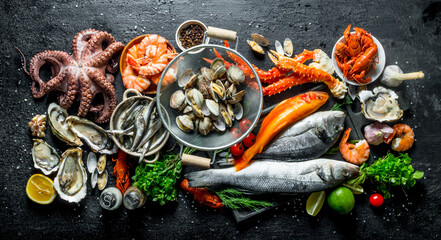 Variety of fresh seafood with herbs and lime. - obrazy, fototapety, plakaty