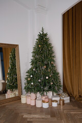 The interior of a room decorated for Christmas with a large mirror and gifts under the Christmas tree