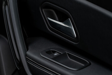 Fototapeta na wymiar Car door handle closeup view. Car interior door panel. Modern car door panel close-up view.