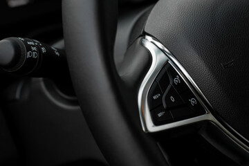 Cruise control switch closeup. Adaptive cruise control leaver. Cruise control on steering wheel.