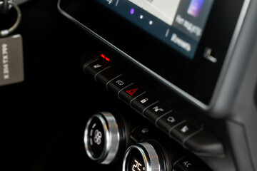 Red triangle hazard light button on car dashboard. Car media buttons dashboard. Detail of a modern car controllers.