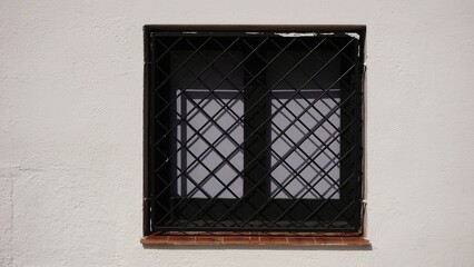 window with grille on the facade