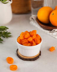 Orange kumquat in a bowl on the table. The concept of candied fruits, dried fruits. 