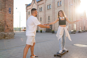Fototapeta premium Couple having fun while driving a long board.