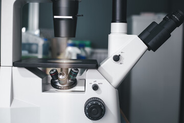 The inverted microscope, microscopy with metal lens and glass slide use for bioassay to look at cells in the laboratory. Research for pharmaceutical, medicine, and biotechnology development.