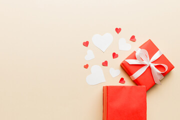 Happy valentines day opened heart shape gift box with small hearts, on colored background, valentines day card - top view concept