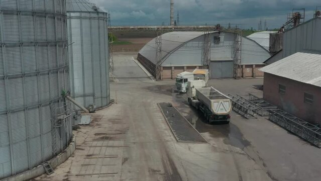Large silver granary. Modern grain elevators. Metal industrial silos for agribusiness. New plant for storing crop. Close-up. Drone view.