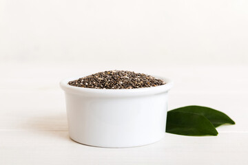 Chia seeds in bowl on colored background. Healthy Salvia hispanica in small bowl. Healthy superfood