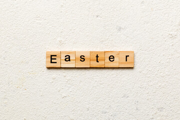 Easter word written on wood block. Easter text on cement table for your desing, concept