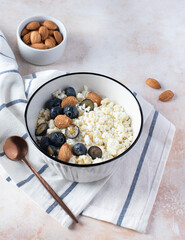 Cottage cheese with blueberries, honey and almonds in a ceramic plate