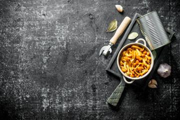Canned honey agaric on a cutting Board with garlic and Bay leaf.