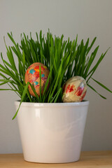 Colorful Easter nail polish painted eggs in the grass in th pot, handmade homemade diy decoration on the table