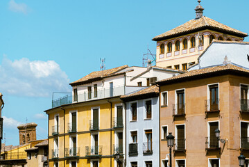 Toledo, España. April 29, 2022: City buildings with colorful facade and blue sky. - obrazy, fototapety, plakaty