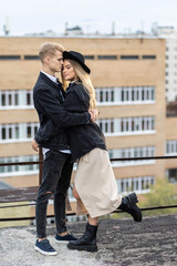 Beautiful happy young loving couple on a surprise date on a Saint Valentine's Day. Romantic modern wedding on the rooftop, summertime. Young man and beautiful girl. Newlyweds on honeymoon boho style