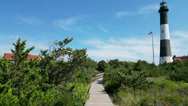 Drone view moving over the boardwalk leading to the Fire Island Lighthouse
