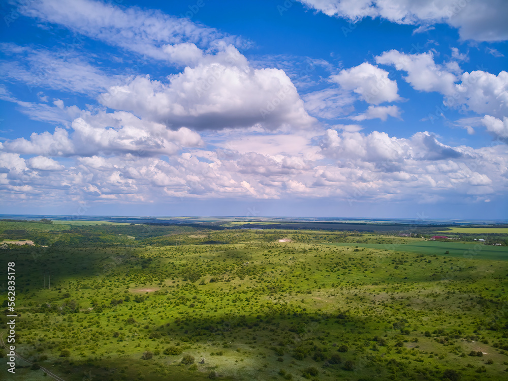 Wall mural Splendid aerial photography of green wavy field in sunny day. Top view drone shot. Agricultural area of Ukraine, Europe.