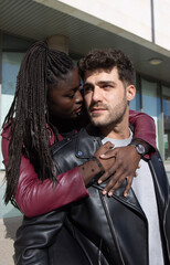 Multiracial couple hugs while she looks at him