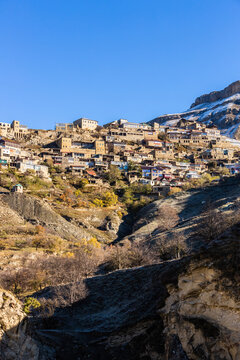 Chokh village close up, Dagestan, Russia. Panoramic view of the village Chokh on the backdrop of snowy mountains. Historic houses and streets on slopes
