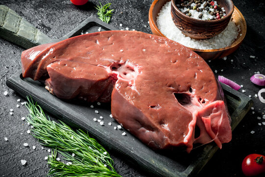 Raw liver with dill and spices in bowl.