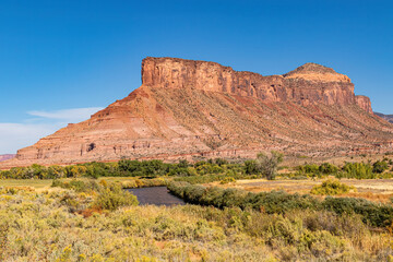 Fototapeta premium River meandering at the base of a red butte in Captial Reef National Park Utah. 