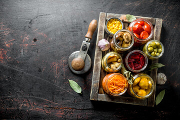 Various preserved vegetables on wooden tray.