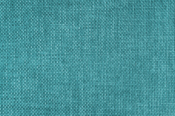 Jacquard woven upholstery, bright turquoise coarse fabric texture. Textile background, furniture textile material, wallpaper, backdrop. Cloth structure close up.
