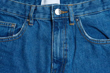 Front side and pockets of blue jeans pants close-up. Denim background, texture, wallpaper, fashion...
