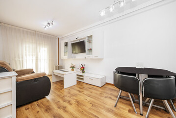 Living room of a house with a designer dining table with matching chairs, all in black and chrome metal