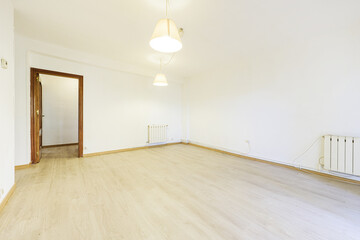 Living room of an empty house with sapele doors and light wooden flooring and pendant lamps from the ceiling