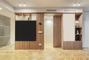 Apartment with custom-made oak wood bookcase with holes to paint and varnished French oak parquet floors placed in a herringbone pattern