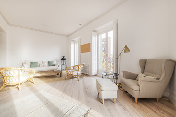 Loft-style apartment with a living room furnished with wooden furniture, several sofas of different sizes and balconies facing the street