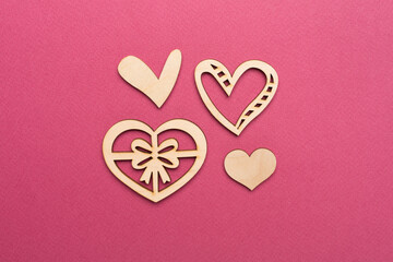 Wooden hearts on color background, top view