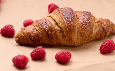 Baked crispy croissant on a wooden board, breakfast
