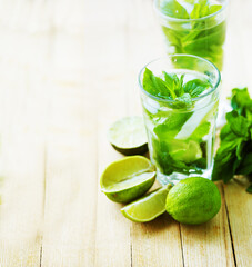 summer coctail background with fresh Mojito over rustic wooden background