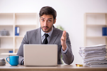 Young male employee and too much work in the office