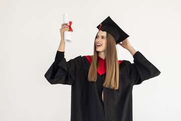 Young graduate woman student in mantle with diploma, isolated on white background