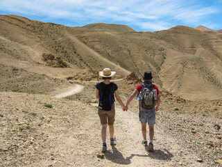 young couple holding hands and hiking