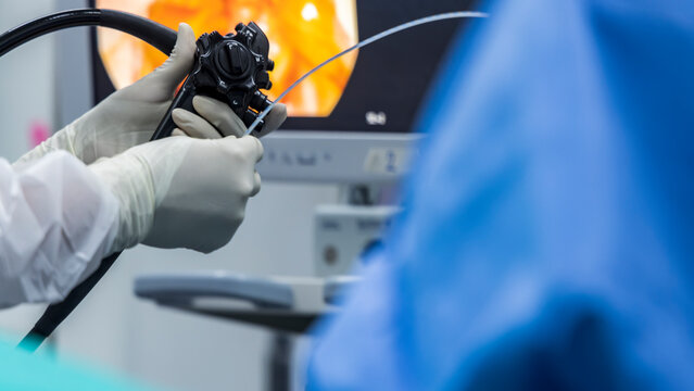 Close up photo of surgeon 's hands inside modern operating room in blue surgical gown suit. Doctor using endoscopic retrograde cholangio pancreatography in gall stone patient with abdominal pain.