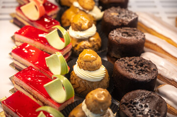 Assortment of french fresh baked sweet pastry with fresh fruits and berries in confectionery shop
