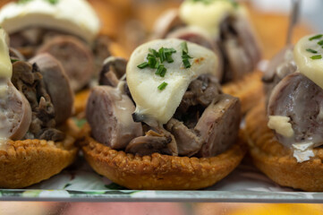 French mini quiche pie with goat cheese and traditional French sausage Andouillette from Troyes in bakery