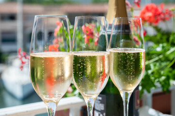 Drinking of French brut champagne sparkling wine in glasses in yacht harbour of Port Grimaud near Saint-Tropez, French Riviera vacation, France