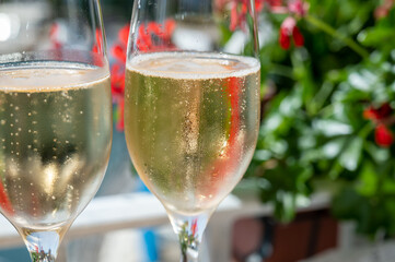 Drinking of French brut champagne sparkling wine in glasses in yacht harbour of Port Grimaud near Saint-Tropez, French Riviera vacation, France