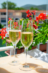 Drinking of French brut champagne sparkling wine in glasses in yacht harbour of Port Grimaud near Saint-Tropez, French Riviera vacation, France