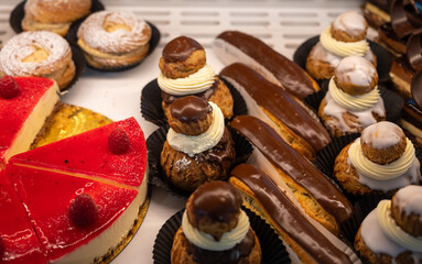 Assortment of french fresh baked sweet pastry with fresh fruits and berries in confectionery shop