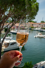 Summer party, drinking of French brut champagne sparkling wine in glasses in yacht harbour of Port Grimaud near Saint-Tropez, French Riviera vacation, France