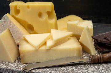 Assortment of Swiss cheeses Emmental or Emmentaler medium-hard cheese with round holes, Gruyere, appenzeller used for traditional cheese fondue and gratin