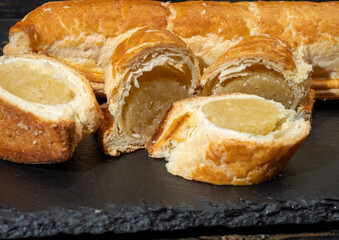 Fresh baked Dutch filled spicy cookies from puff pastry with almonds in autumn colors on dark stone