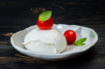 Сheese collection, one big ball on soft white italian mozzarella bufala cheese with red tomato and green basil leaves