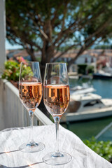 Drinking of French brut champagne sparkling wine in glasses in yacht harbour of Port Grimaud near Saint-Tropez, French Riviera vacation, France